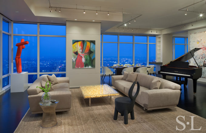 Manhattan residence living room at dusk with sweeping views of New York, featuring a painting by Jim Dine and a coffee table by Yves Kline