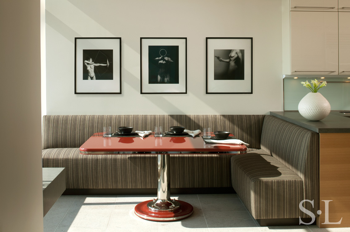 Manhattan residence breakfast room with three photographs by Robert Mapplethorpe, a banquette and red metal and lacquer Yacht Table
