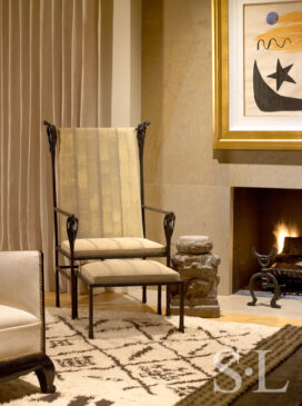 Living room fireplace detail showing chair by Ingrid Donat and Gene Summers andirons