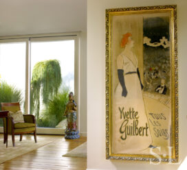 Master bedroom detail with large artwork by Toulouse-Lautrec, seating and a view of exterior landscaping