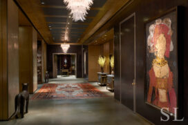 Entry gallery of Chicago skyline penthouse with walls in dark cashew lacquered plaster