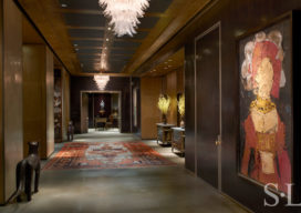 Entry gallery of Chicago skyline penthouse with walls in dark cashew lacquered plaster