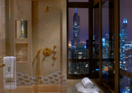 Penthouse wet room with honey onyx mosaic and view of Chicago skyline at night