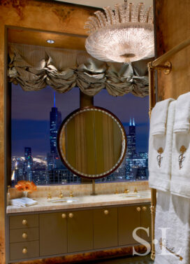 Penthouse primary bathroom vanity area with view of Chicago skyline at night