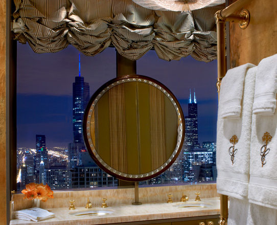 Penthouse primary bathroom vanity area with view of Chicago skyline at night