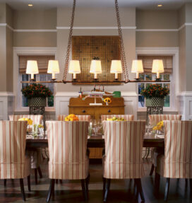 Restored landmark residence on former military base dining room with penny-pitch board on wall above a whirligig by Ed Larson