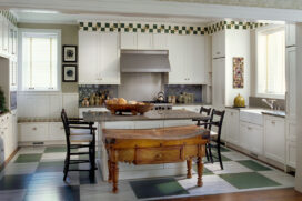 Restored landmark residence on former military base kitchen with green-and-white painted checkerboard floor and antique Irish butcher block table