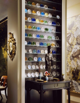 Chicago townhome entry detail with a bronze Kuan Yin statue and collection of Boston & Sandwich cup plates