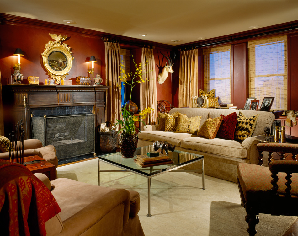 1920s era Lake Shore Drive penthouse library with red walls and round mirror above fireplace