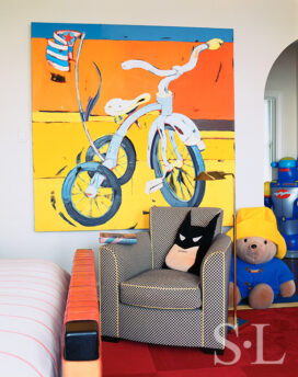 Young boy's bedroom with bicycle artwork, batman pillow and stuffed Paddington