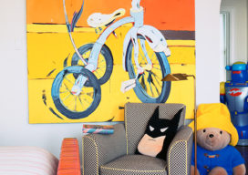 Young boy's bedroom with bicycle artwork, batman pillow and stuffed Paddington
