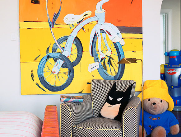 Young boy's bedroom with bicycle artwork, batman pillow and stuffed Paddington