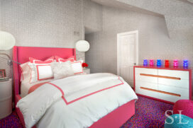 Girl's bedroom with view of bed and dresser designed in white, pinks and blues