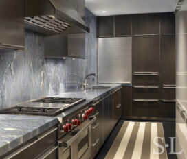 Contemporary kitchen design in waterfront townhome includes Caribbean Blue Quartzite countertops and backsplash, Bulthaup cabinetry and Sub Zero range and oven.