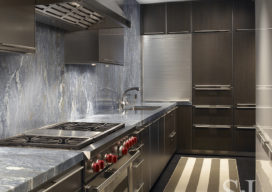 Contemporary kitchen design in waterfront townhome includes Caribbean Blue Quartzite countertops and backsplash, Bulthaup cabinetry and Sub Zero range and oven.