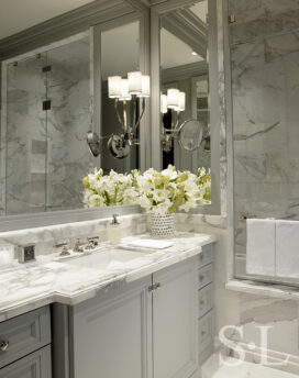 The primary bathroom in waterfront townhome features Calacatta Gold Marble and polished nickel faucetry by Waterworks