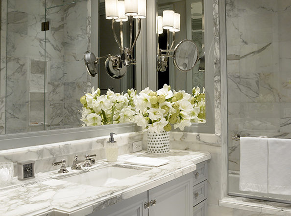 The primary bathroom in waterfront townhome features Calacatta Gold Marble and polished nickel faucetry by Waterworks