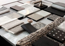 A black and white interior design palette of fabrics, rugs and hardware
