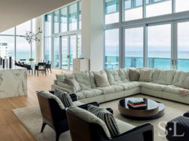 With panoramic ocean views, this contemporary great room features double height ceilings and a sofa by Paola Navone