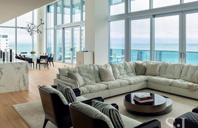 With panoramic ocean views, this contemporary great room features double height ceilings and a sofa by Paola Navone