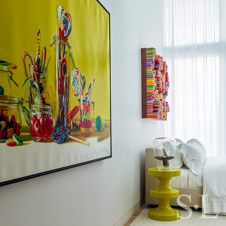 Guest bedroom with artwork by Roberto Bernardi and side table by India Mahdavi