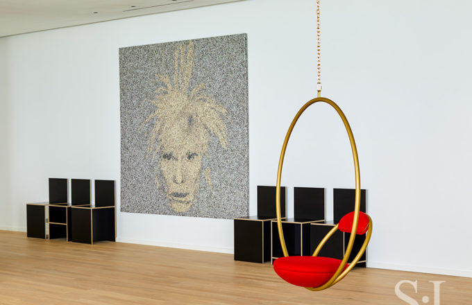 Entry gallery with artwork by Joseph and a set of plywood chairs by Donald Judd