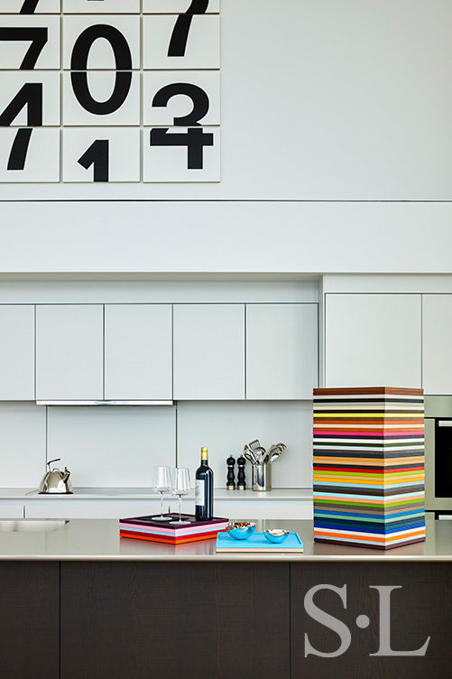 Contemporary kitchen detail showing artwork by Darren Almond and stacked leather trays by Giobagnara Arcobaleno