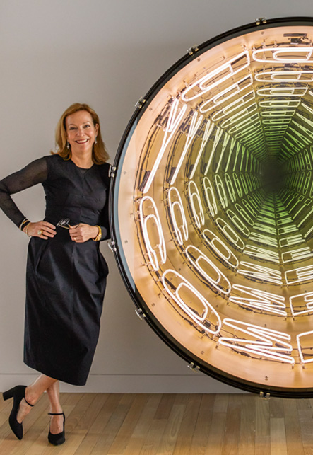 Portrait of Suzanne Lovell in entryway of a residence she designed in Miami Beach with artwork by Iván Navarro