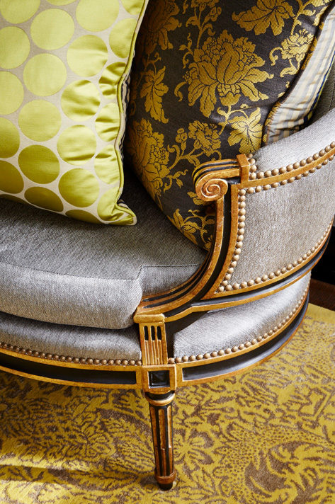 Custom bergère settee in black with antique gold frame and nailhead detail with pillows