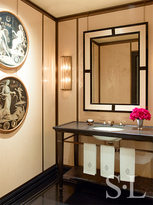 Powder room showcasing an antique mirror and sconces