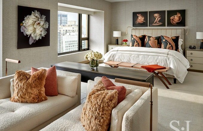 Chicago luxury apartment bedroom in warm neutral tones showing seating area and bed