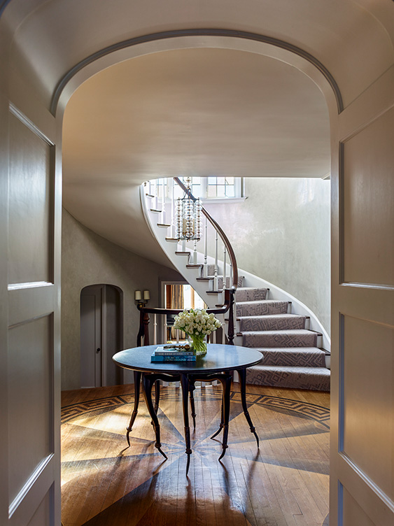 Scarsdale, NY residence entry foyer renovation with Michael Wilson table, curved staircase and Paul Ferrante pendant light fixture