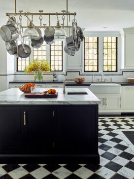 Scarsdale, NY kitchen renovation with original leaded windows, black and white floor and large black center island with pot rack above
