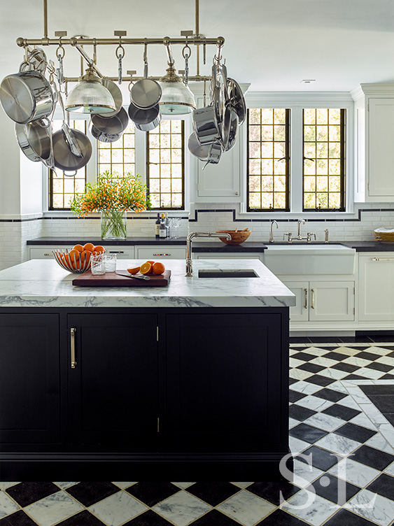 Scarsdale, NY kitchen renovation with original leaded windows, black and white floor and large black center island with pot rack above