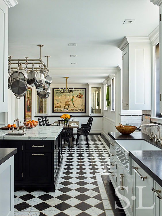 Scarsdale, NY kitchen renovation long-view with black and white checkered limestone and marble floor, a large black center island with pot rack above and kitchen table