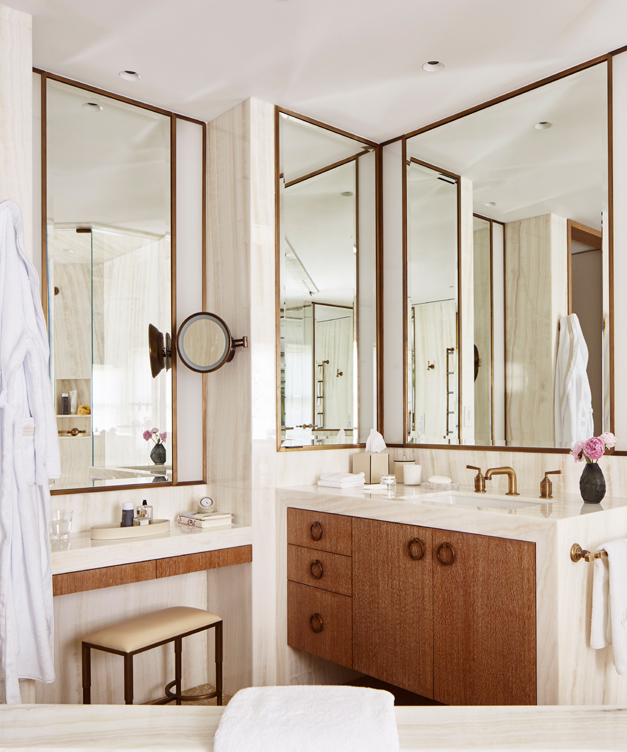 Master bath showing cantilevered cerused oak vanities and beveled bronze-framed mirrors
