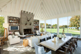 Great room with fireplace, seating and dining areas and views to Lake Geneva through floor to ceiling windows