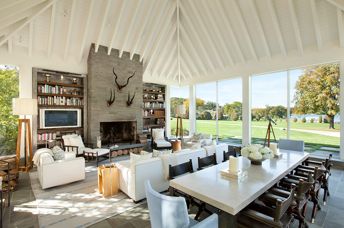 Great room with fireplace, seating and dining areas and views to Lake Geneva through floor to ceiling windows