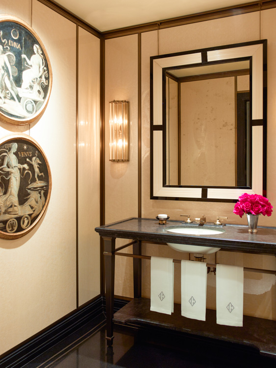 Powder room showcasing an antique mirror and sconces