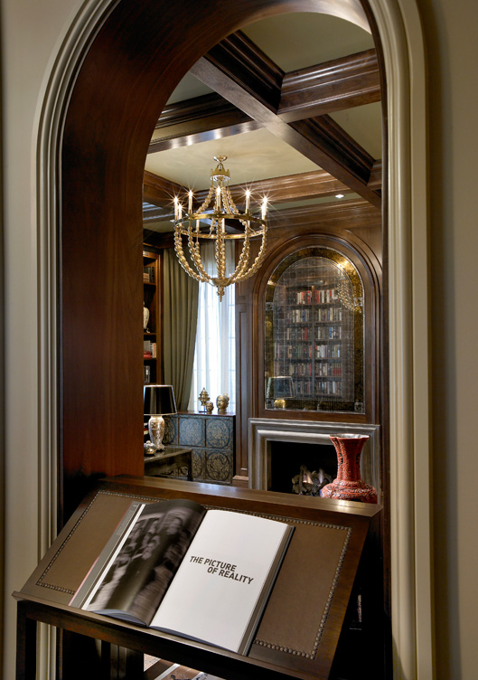View into library through dark walnut-lined archway in Chicago Lincoln Park residence