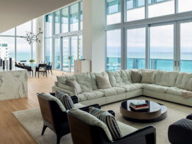 With panoramic ocean views, this contemporary great room features double height ceilings and a sofa by Paola Navone