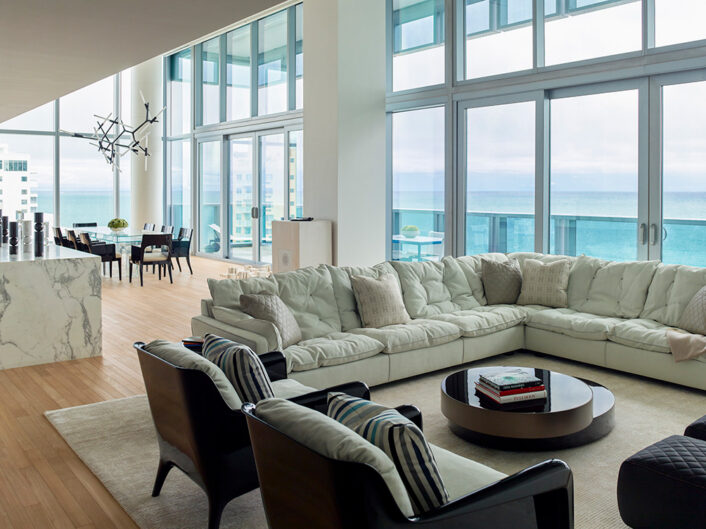 With panoramic ocean views, this contemporary great room features double height ceilings and a sofa by Paola Navone
