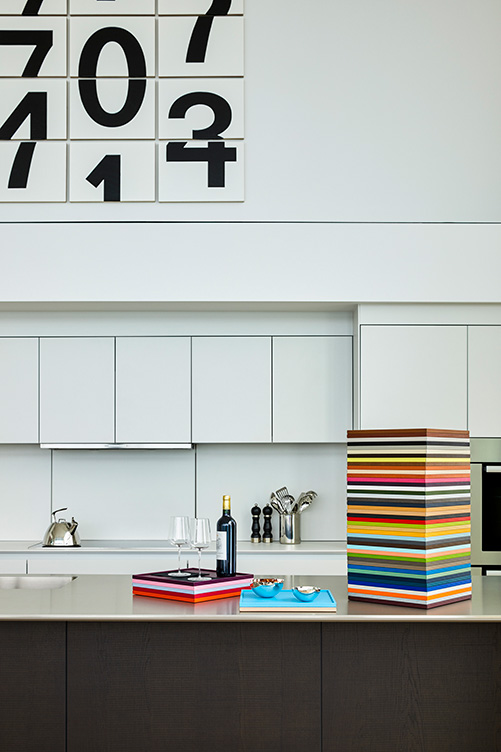 Contemporary kitchen detail showing artwork by Darren Almond and stacked leather trays by Giobagnara Arcobaleno