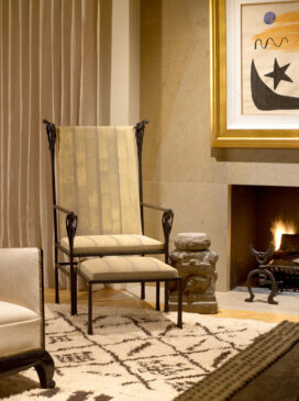 Living room fireplace detail showing chair by Ingrid Donat and Gene Summers andirons