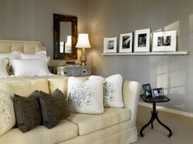 Deco-era duplex apartment primary bedroom with blue-gray upholstered walls and a picture rail with photos by Aaron Siskind
