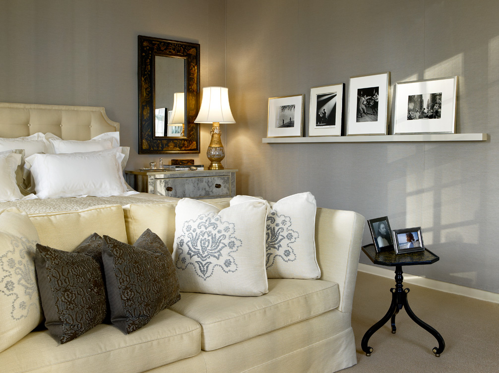 Deco-era duplex apartment primary bedroom with blue-gray upholstered walls and a picture rail with photos by Aaron Siskind