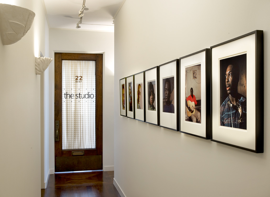 Deco-era duplex apartment hallway with photographs by Lee Friedlander