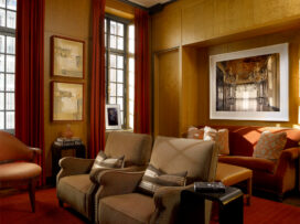 Deco-era duplex apartment media room with curly maple paneling, velvet sofa and artwork by Michael Eastman