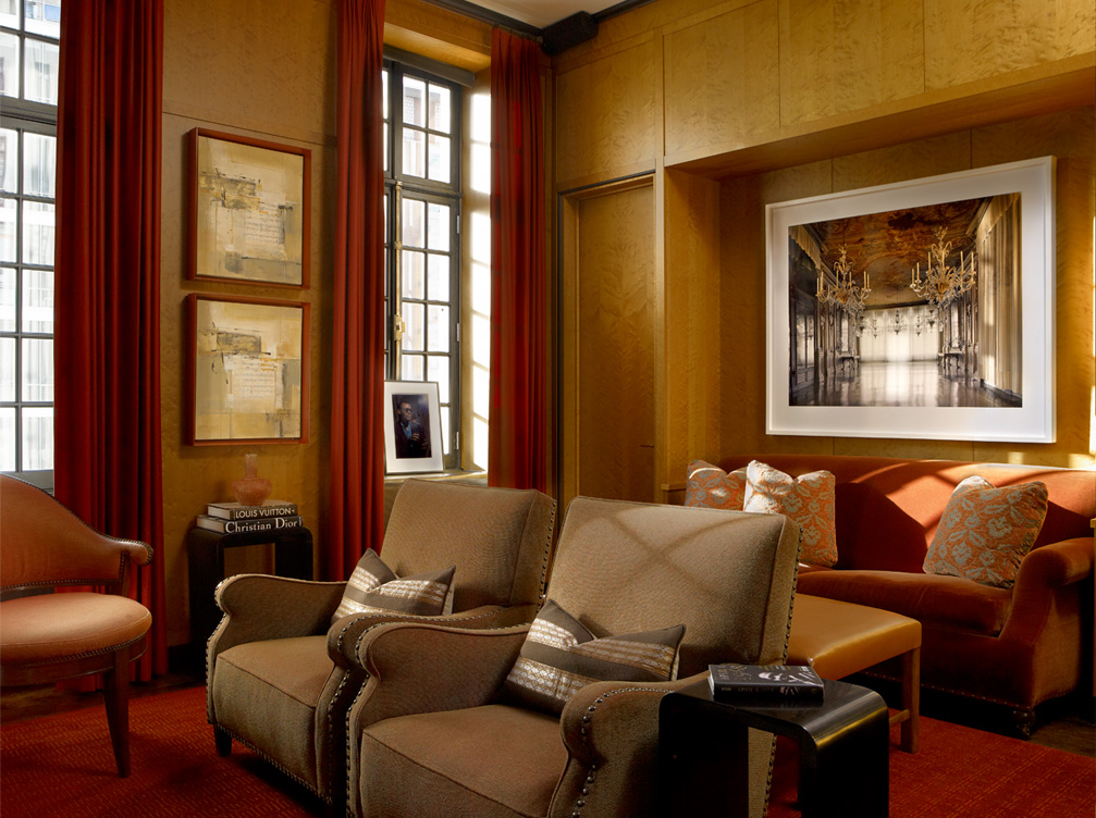 Deco-era duplex apartment media room with curly maple paneling, velvet sofa and artwork by Michael Eastman