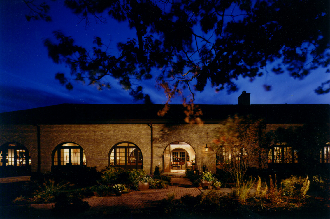 Front exterior at dusk of former artillery shed converted into luxury residence by Suzanne Lovell Inc.